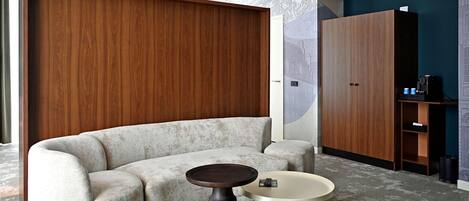 Un salon moderne avec un canapé, une table basse ronde et une cloison en bois.