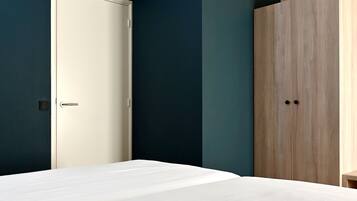 A bedroom with a bed, a wardrobe, and a door.