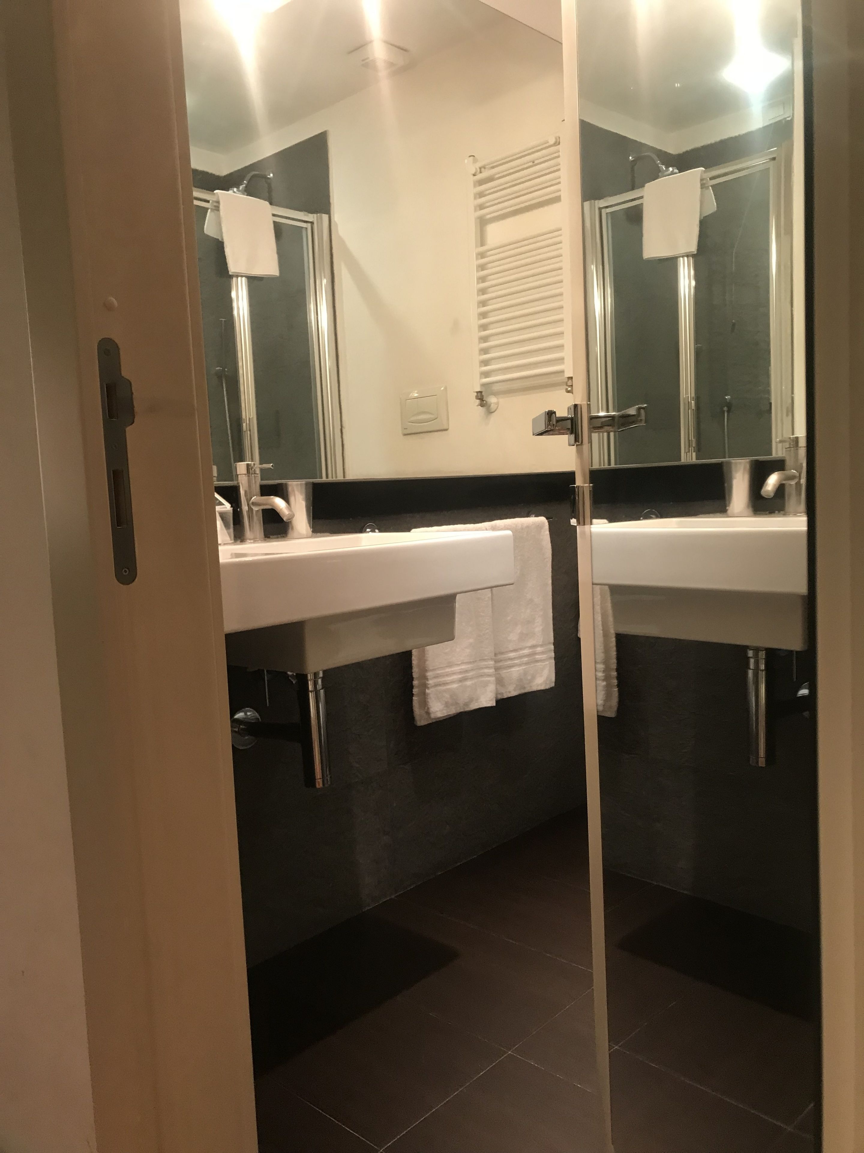 A bathroom with two sinks, a mirror, and a towel rack.