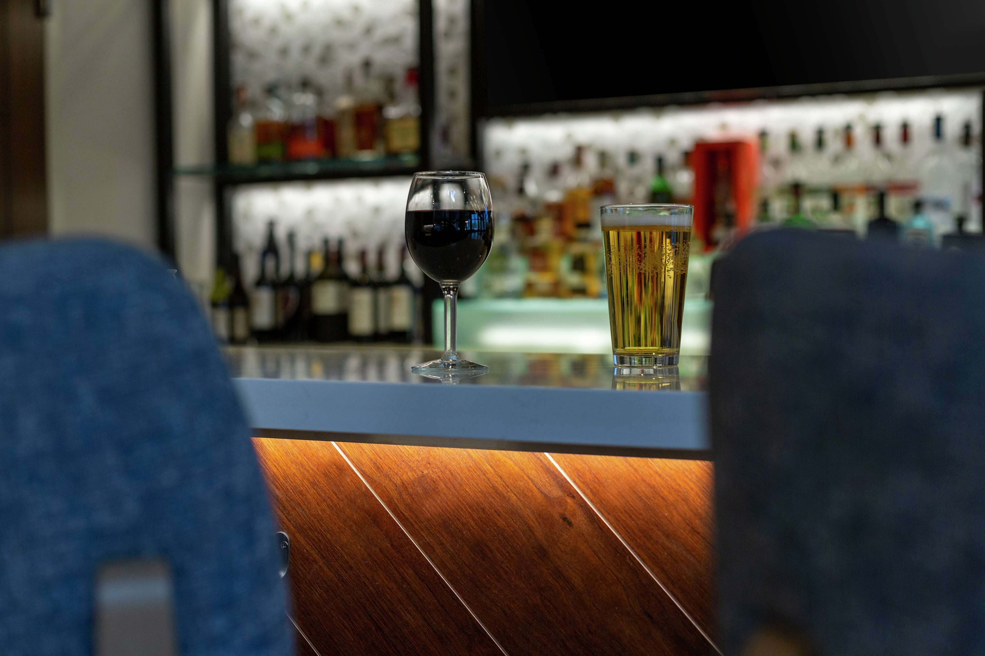 Een bar met een glas rode wijn en een glas bier op de toonbank.