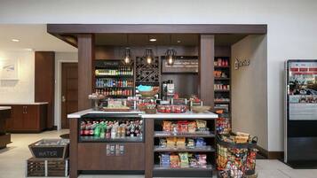 Una cafetería con una variedad de bebidas y aperitivos, incluyendo agua embotellada y café.