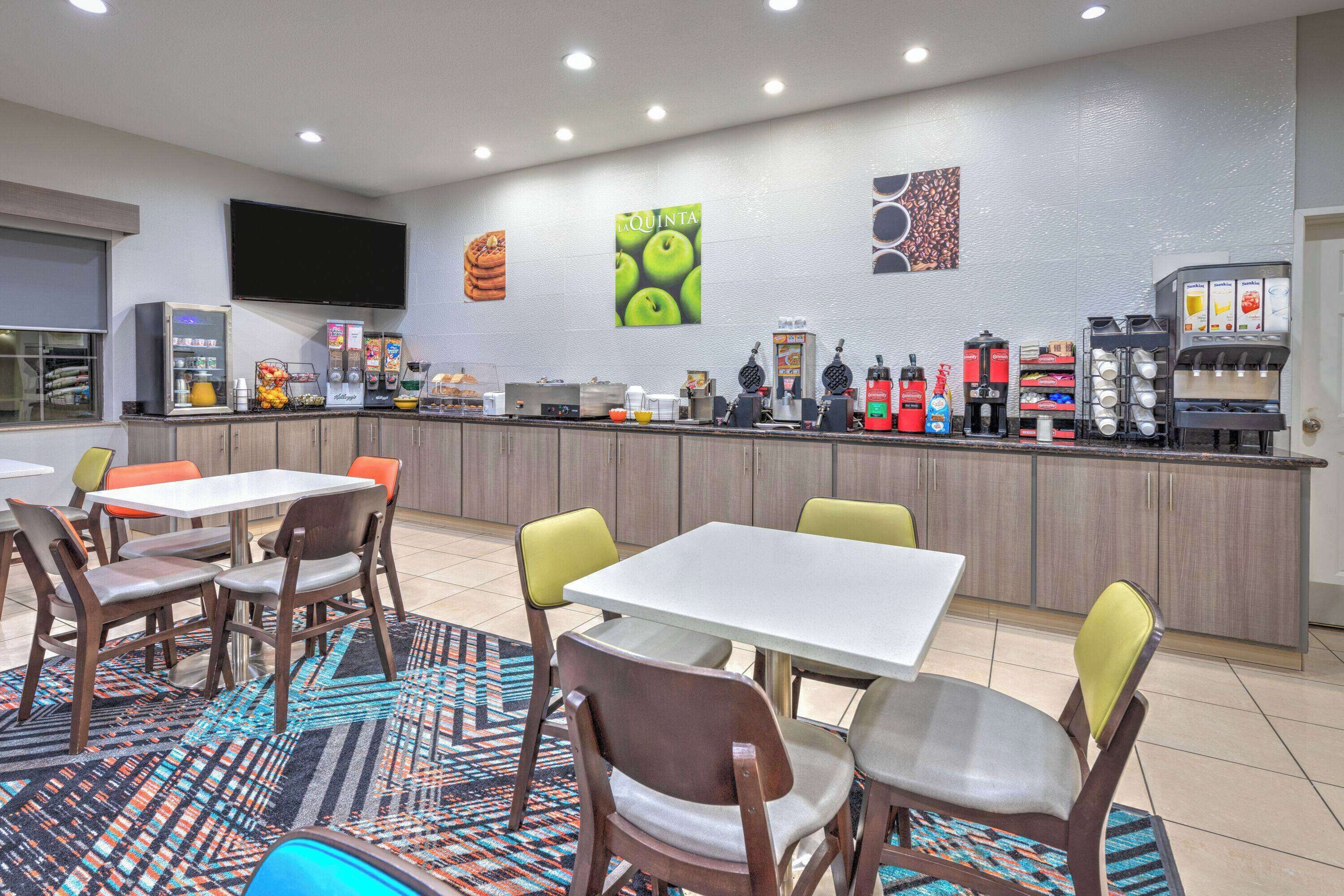 A modern cafe with a counter, seating area, and various food and drink options.