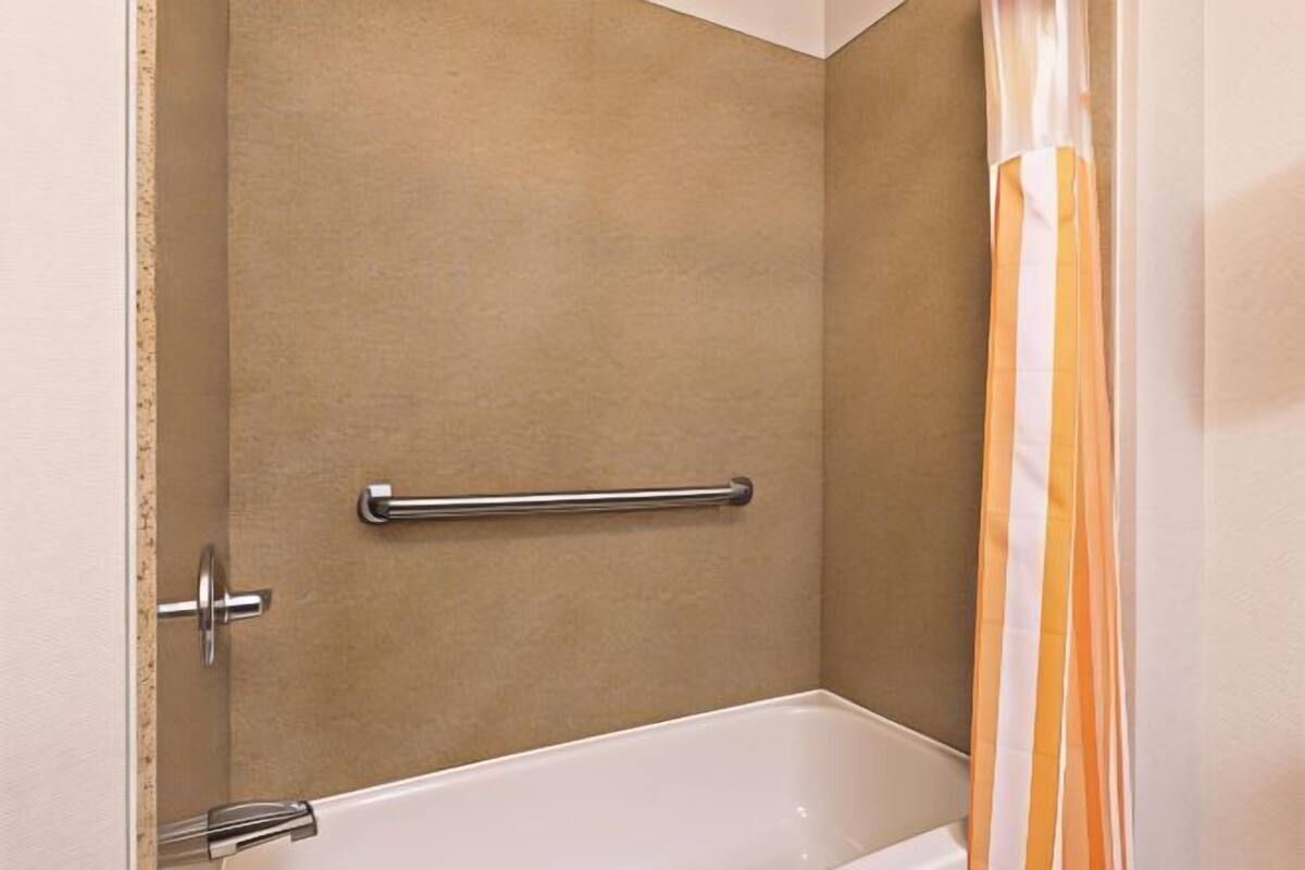 Badkamer | Een bad/douchecombinatie, gratis toiletartikelen, een haardroger