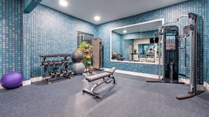 A gym with exercise equipment, a bench, and a mirrored wall. - La Quinta Inn & Suites by Wyndham Alvarado (Alvarado)