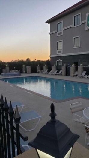 A swimming pool with lounge chairs and a building in the background. - La Quinta Inn & Suites by Wyndham Alvarado (Alvarado)
