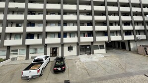A multi-story parking garage with a modern design, featuring a central entrance and a series of balconies on each floor. - Studio 6 Vicksburg, MS - Downtown (Vicksburg)