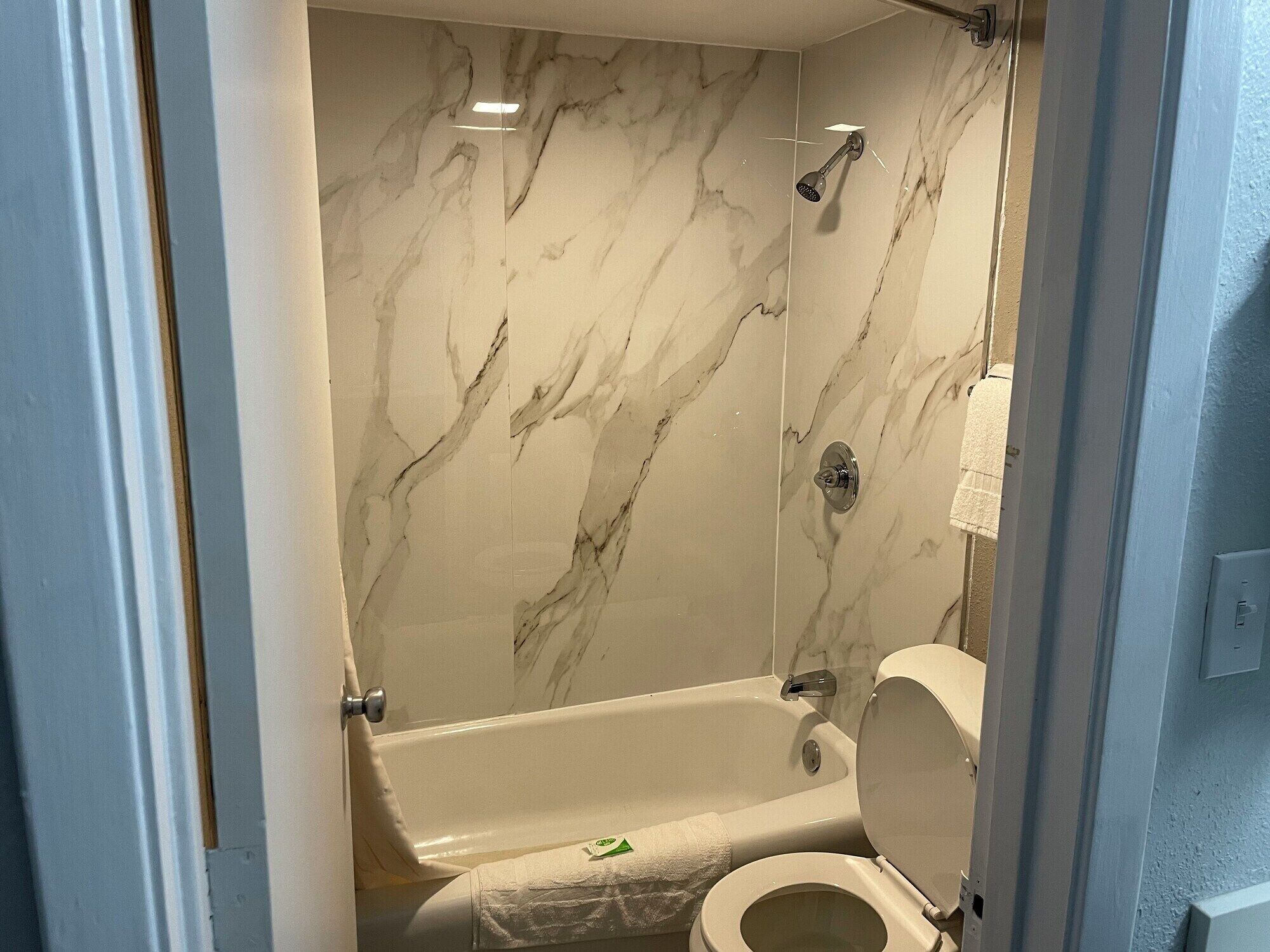 Een regendouche, designer toiletartikelen, een haardroger, handdoeken