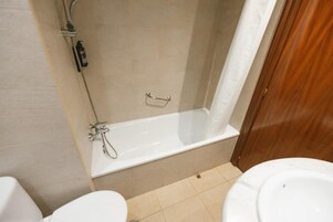 Ein Badezimmer mit Badewanne, Toilette und Dusche.