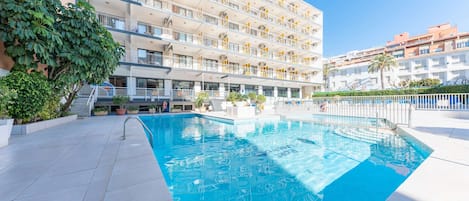 Alberca al aire libre y camastros