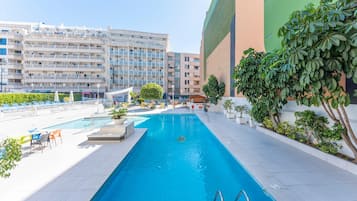 Alberca al aire libre y camastros