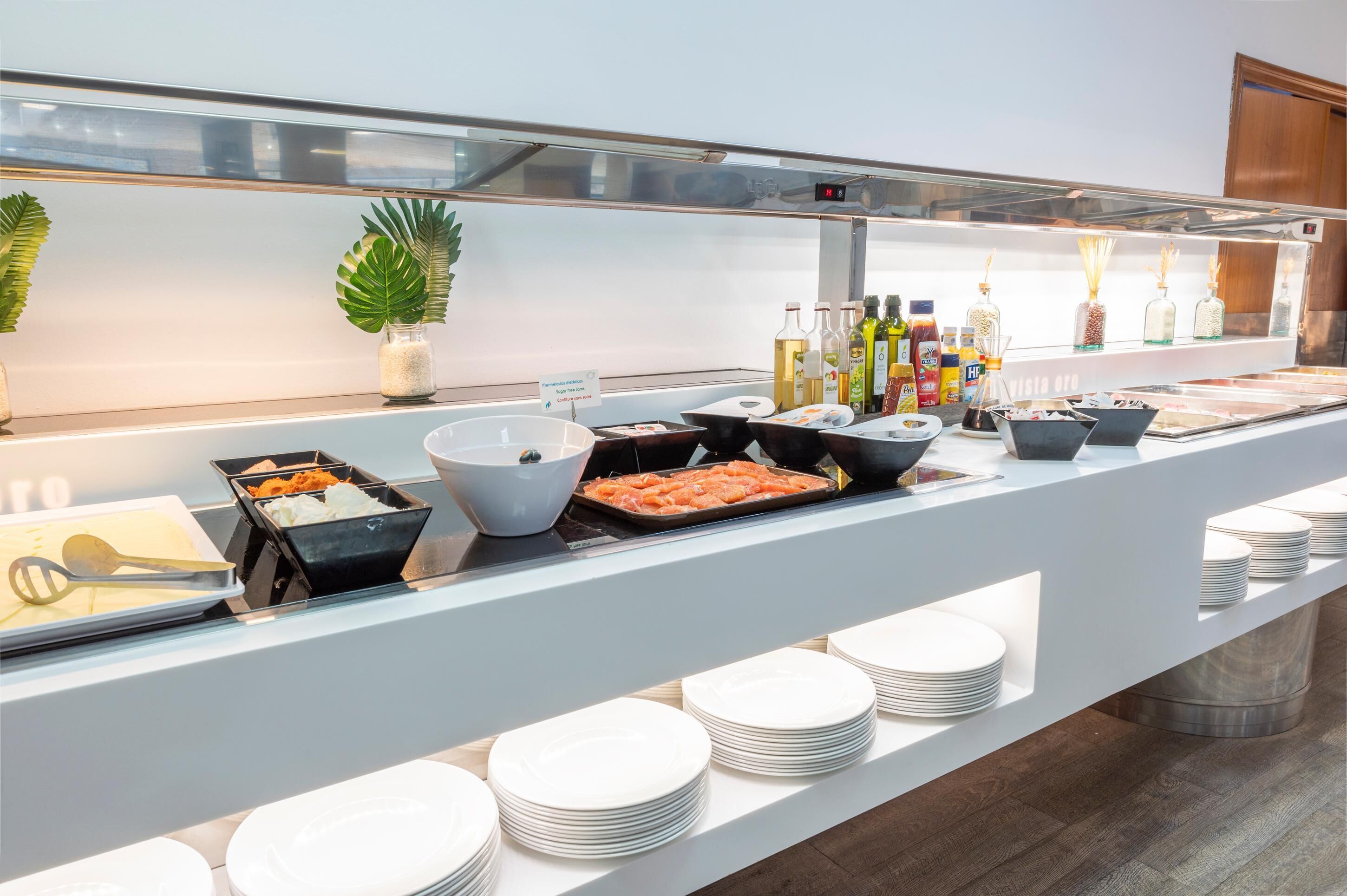 Montaje de bufé con diversos alimentos, salsas y utensilios.