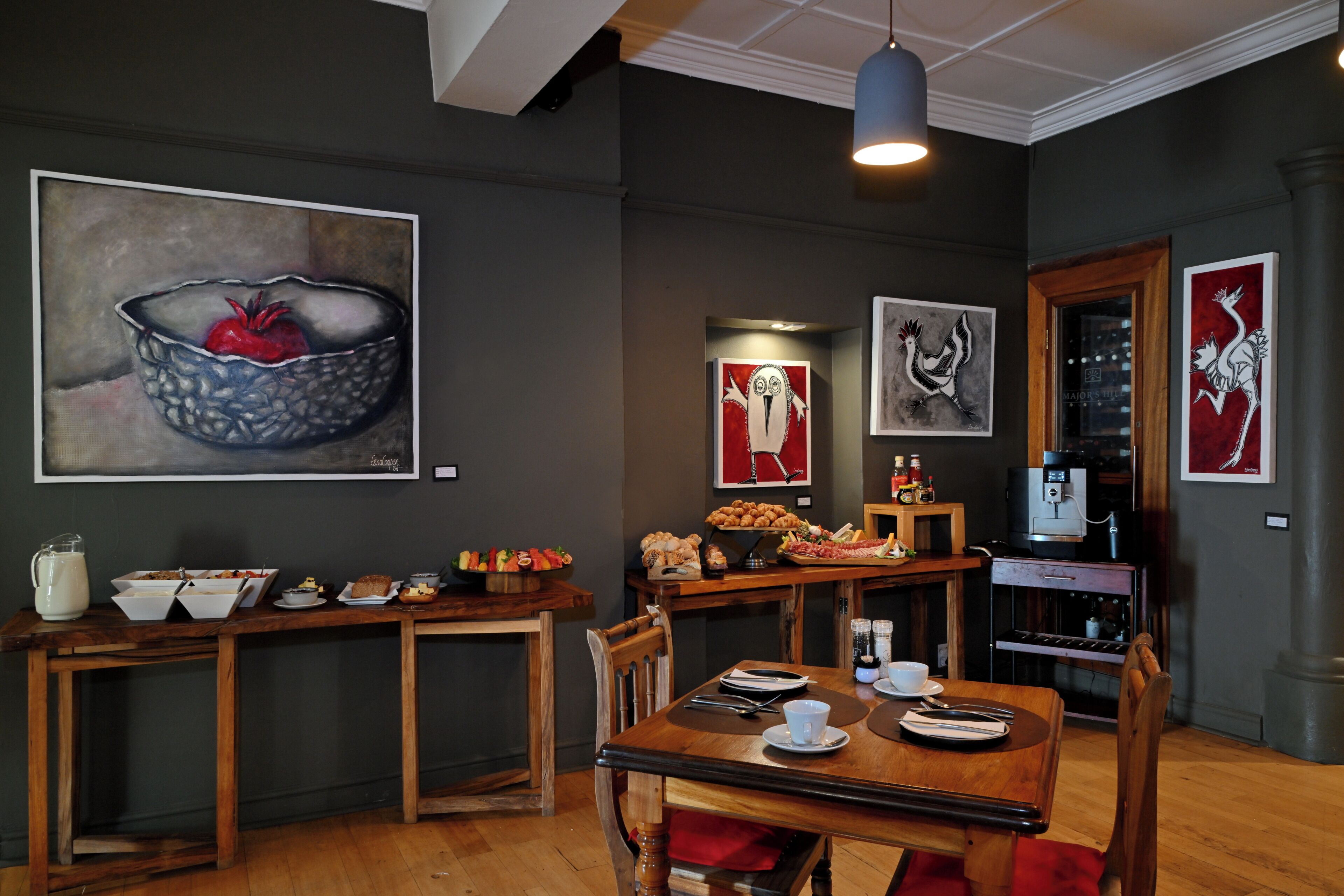A dining area with a wooden table, chairs, and a coffee machine.