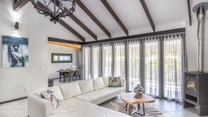 A modern living room with a sectional sofa, a wooden coffee table, and a fireplace. - Mimosa Lodge (Montagu)