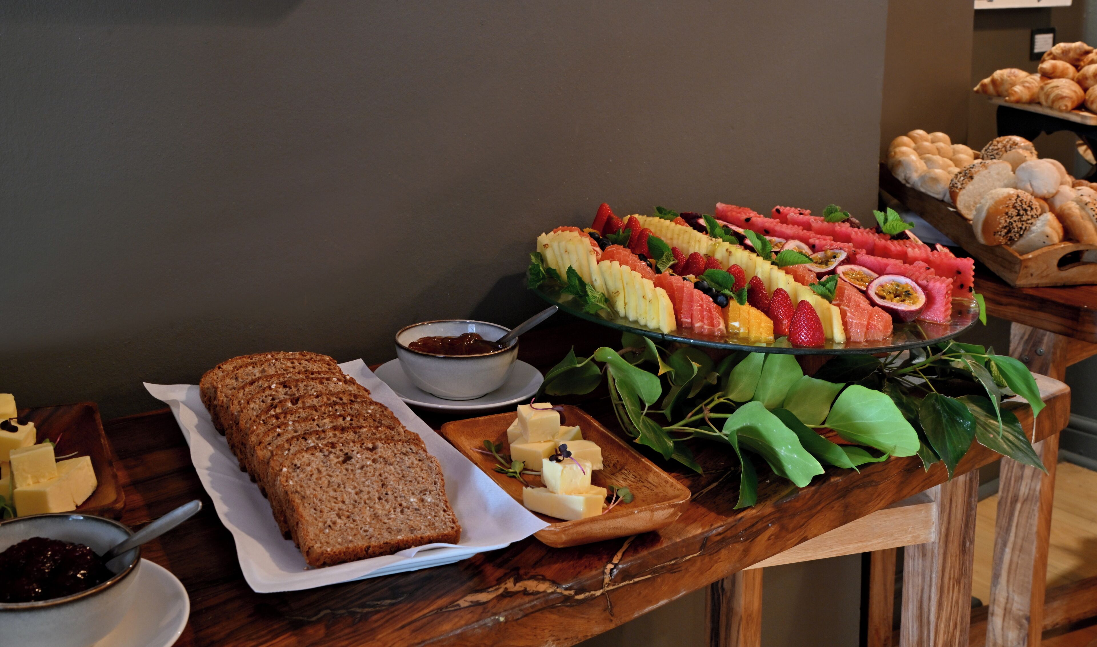Un buffet proposant une variété de plats, notamment du pain, du fromage et un assortiment de fruits.