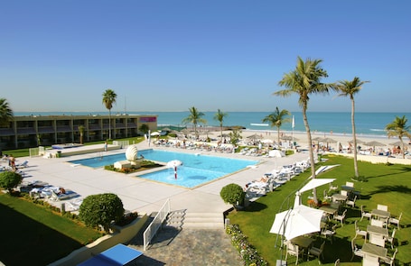 Outdoor pool, pool umbrellas, pool loungers. Lou'lou'a Beach Resort Sharjah