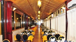 A long dining hall with rows of tables, chairs, and chandeliers. - Safeer Hotel Suites - Aparthotel (Muscat)