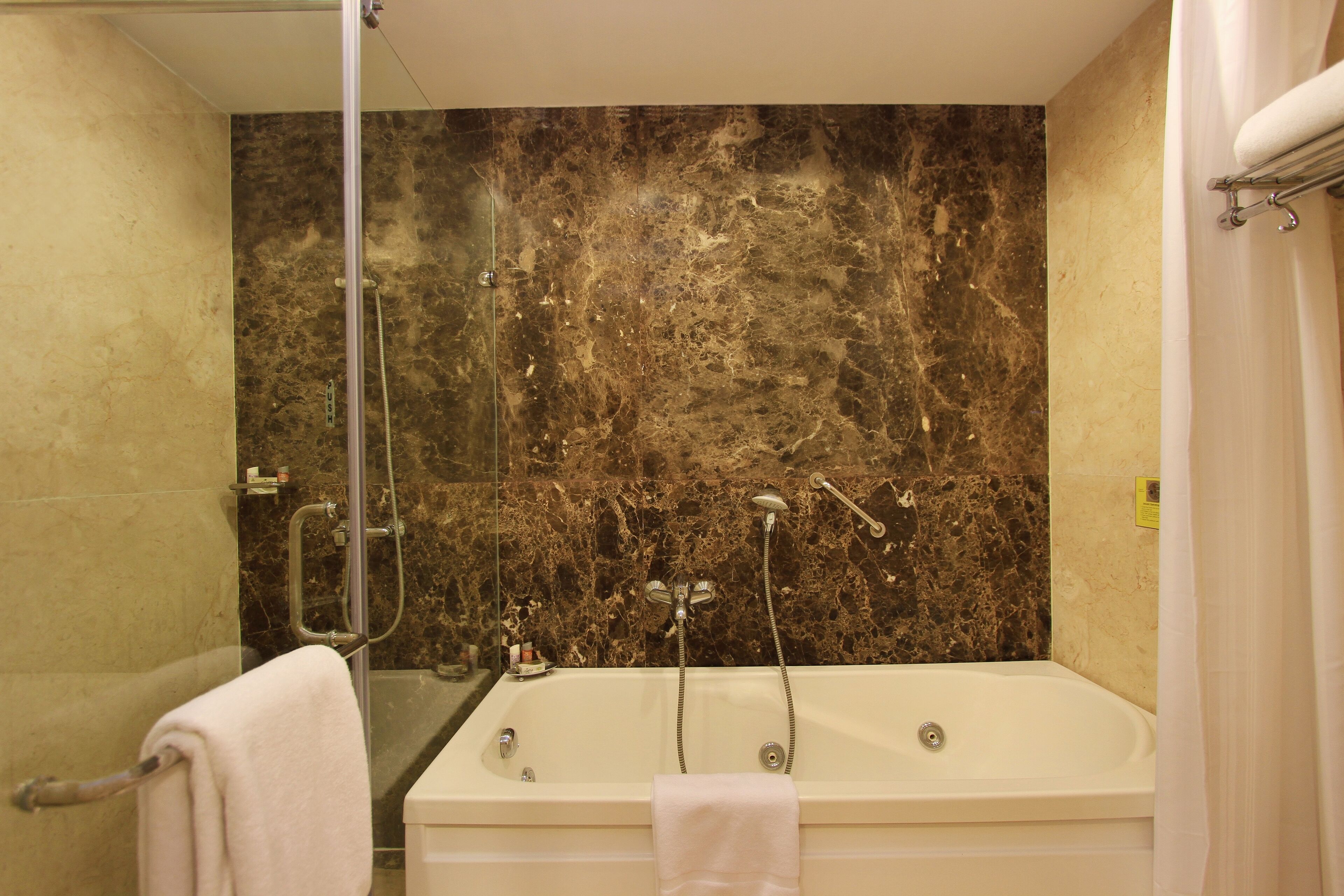 A bathroom with a bathtub, a shower, and a glass-enclosed shower area.