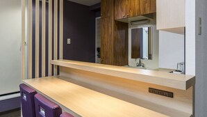 A modern bathroom with a wooden vanity, a mirror, and a light fixture. - Hotel MyStays Asakusa (Tokyo)