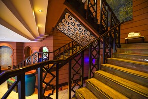 A staircase with ornate metal railings and a patterned wall design. - Kampala Serena Hotel (Kampala)
