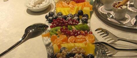 Een buffet met verschillende soorten fruit en desserts.