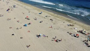 A wide beach with people and umbrellas, a clear sky, and the ocean. - Newport Channel Inn - Near Huntington State Beach (Newport Beach)