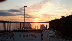 A sunset view with a sign reading "Alexandra Stay Only Guests". - Alexandra Stay Residence (Sirmione)