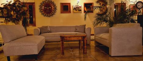 A living room with a sectional sofa, a wooden coffee table, and decorative wall art.