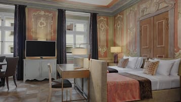 Una habitación de hotel con cama, televisión, escritorio y silla.