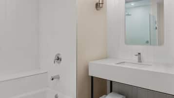 Un baño moderno con una bañera, un lavabo y un espejo.