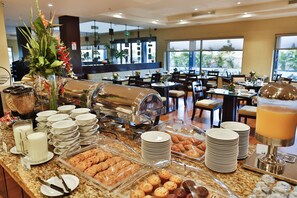 A buffet area with various food items, including pastries and a fruit punch dispenser. - Hilton Garden Inn Guanacaste Airport  (Liberia)