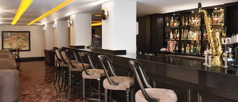 Una zona de bar con taburetes altos, una barra y un saxofón.