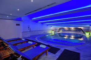 A spa room with a hot tub, wooden loungers, and blue ambient lighting. - Crowne Plaza Istanbul - Old City by IHG (Istanbul)