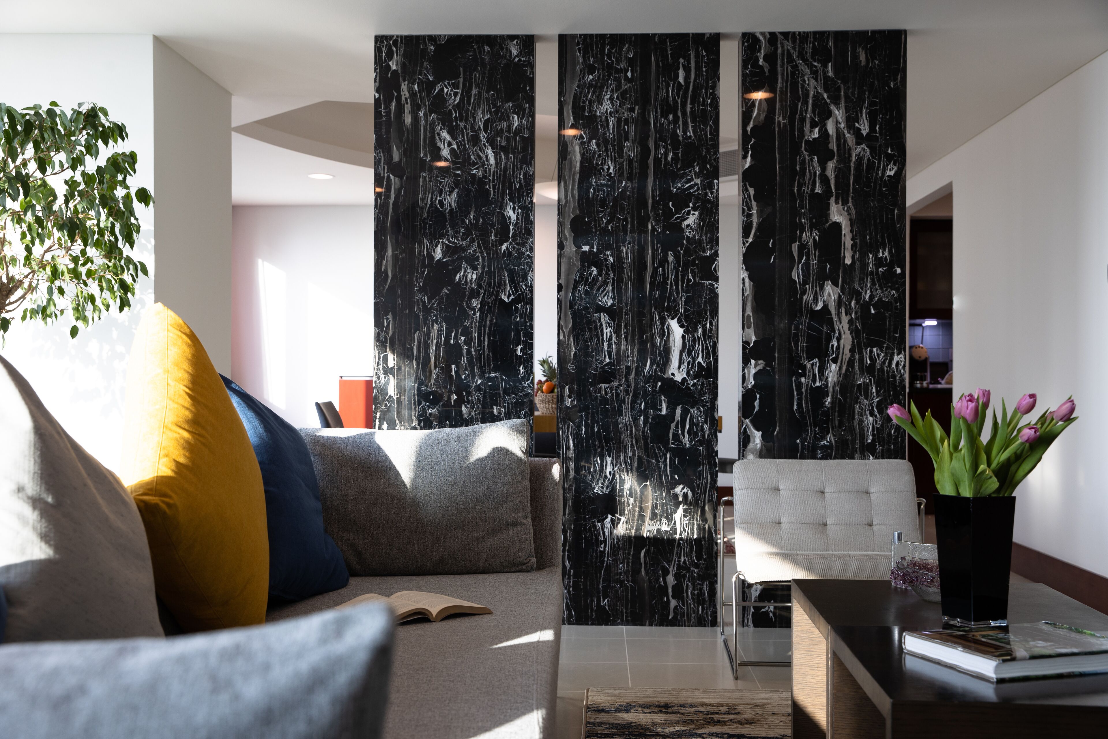 Un salon moderne avec un canapé, une table basse et une plante décorative.