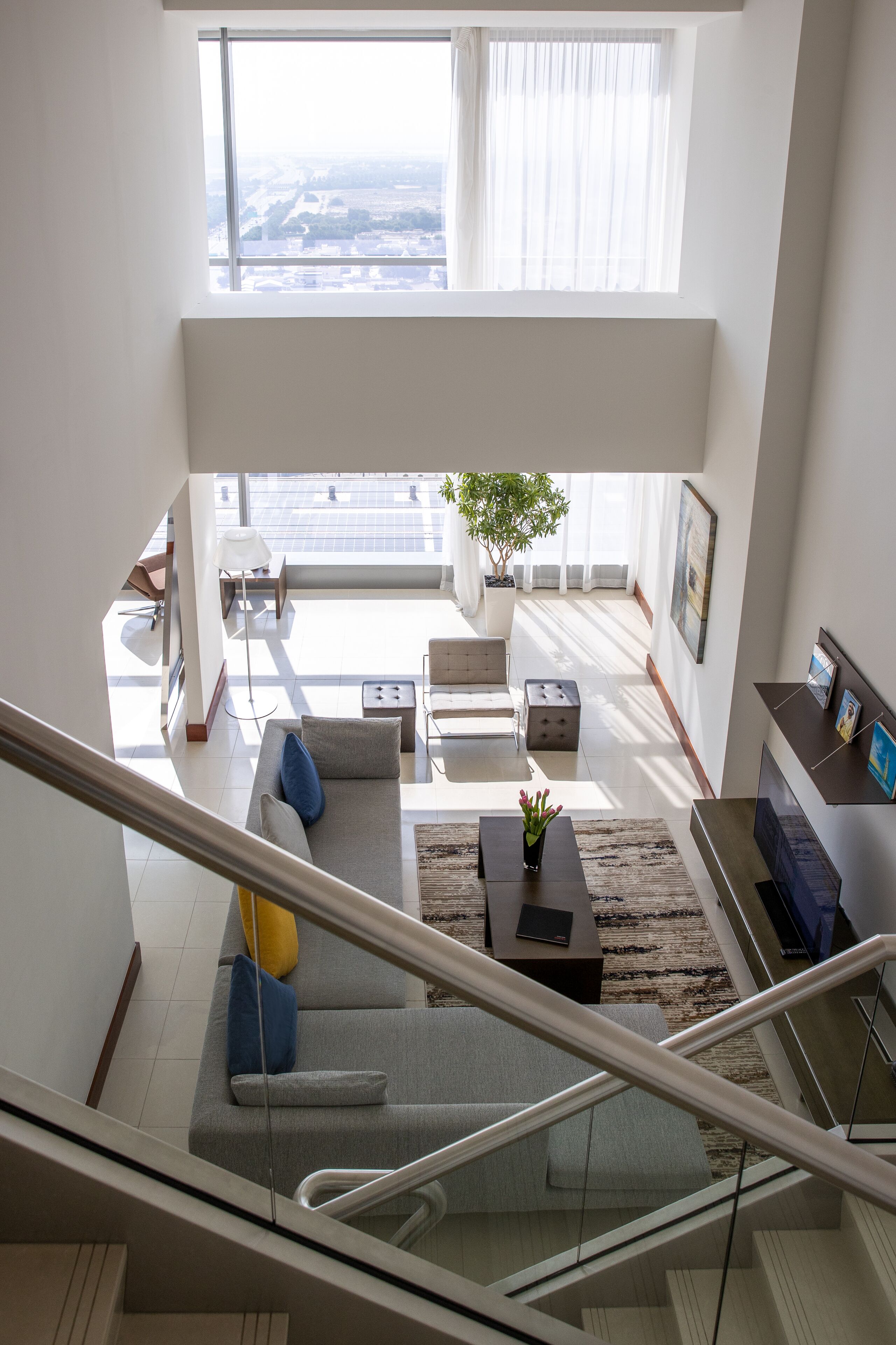 Un vaste espace de vie comprenant un canapé, une table basse et un escalier menant à l’étage supérieur.