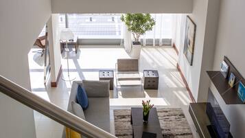 Un vaste espace de vie comprenant un canapé, une table basse et un escalier menant à l’étage supérieur.