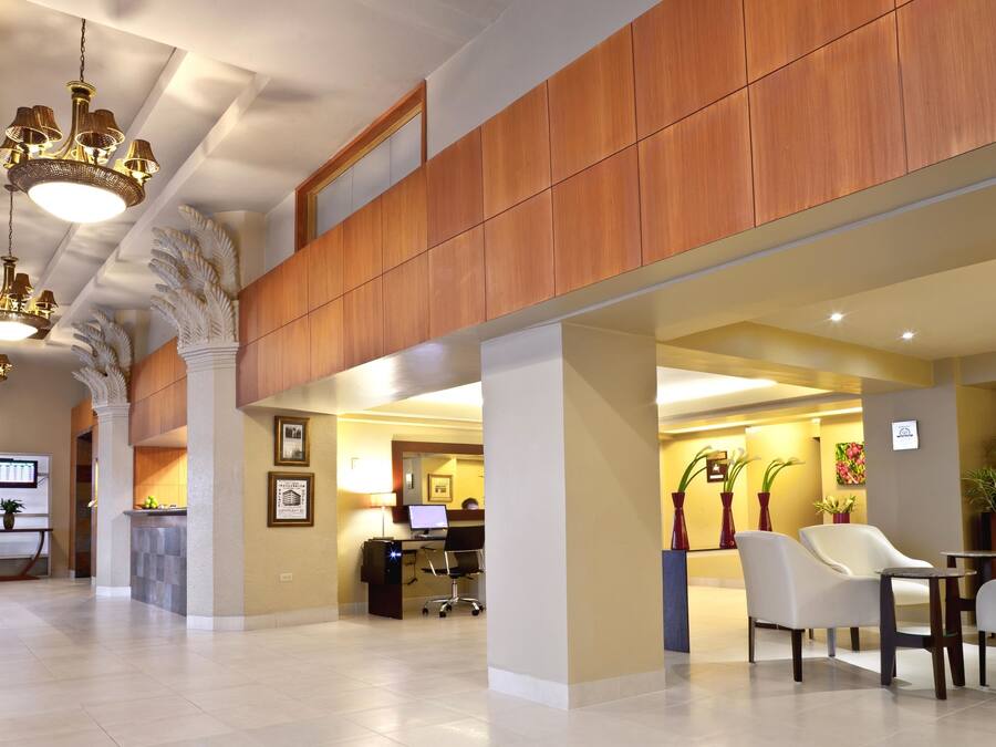 A spacious lobby with high ceilings, wooden paneling, and a reception desk.