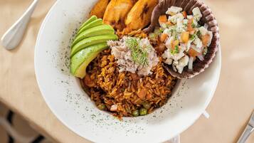 Prato de comida com arroz, abacate e um acompanhamento.