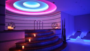 Een moderne spa met een wenteltrap, sfeerverlichting en een decoratieve wand.