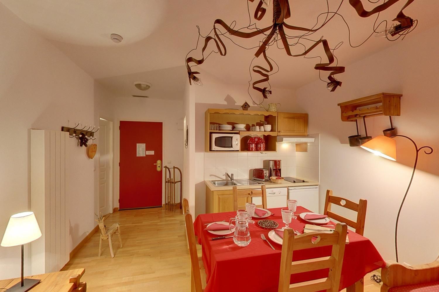 A compact kitchen with a microwave, coffee maker, and wooden cabinets.