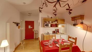 A compact kitchen with a microwave, coffee maker, and wooden cabinets.