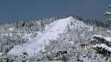 Una muntanya plena de neu amb una estació d'esquí, incloent edificis i telesquí.