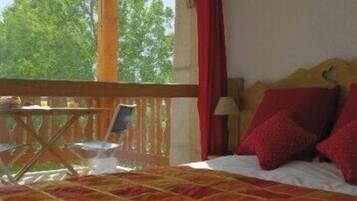 Un dormitorio con cama, una mesita y una silla en un balcón.