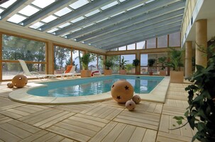 Una piscina techada, sillones reclinables de piscina