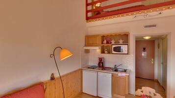Een knus woongedeelte met een kitchenette, een eethoek en een zithoek.