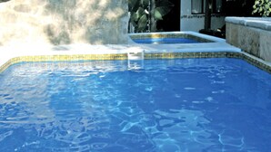 A swimming pool with clear blue water and a tiled edge.