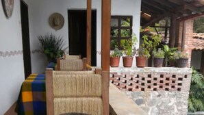 A room with a checkered floor, a stone bench, and a pool area with potted plants.