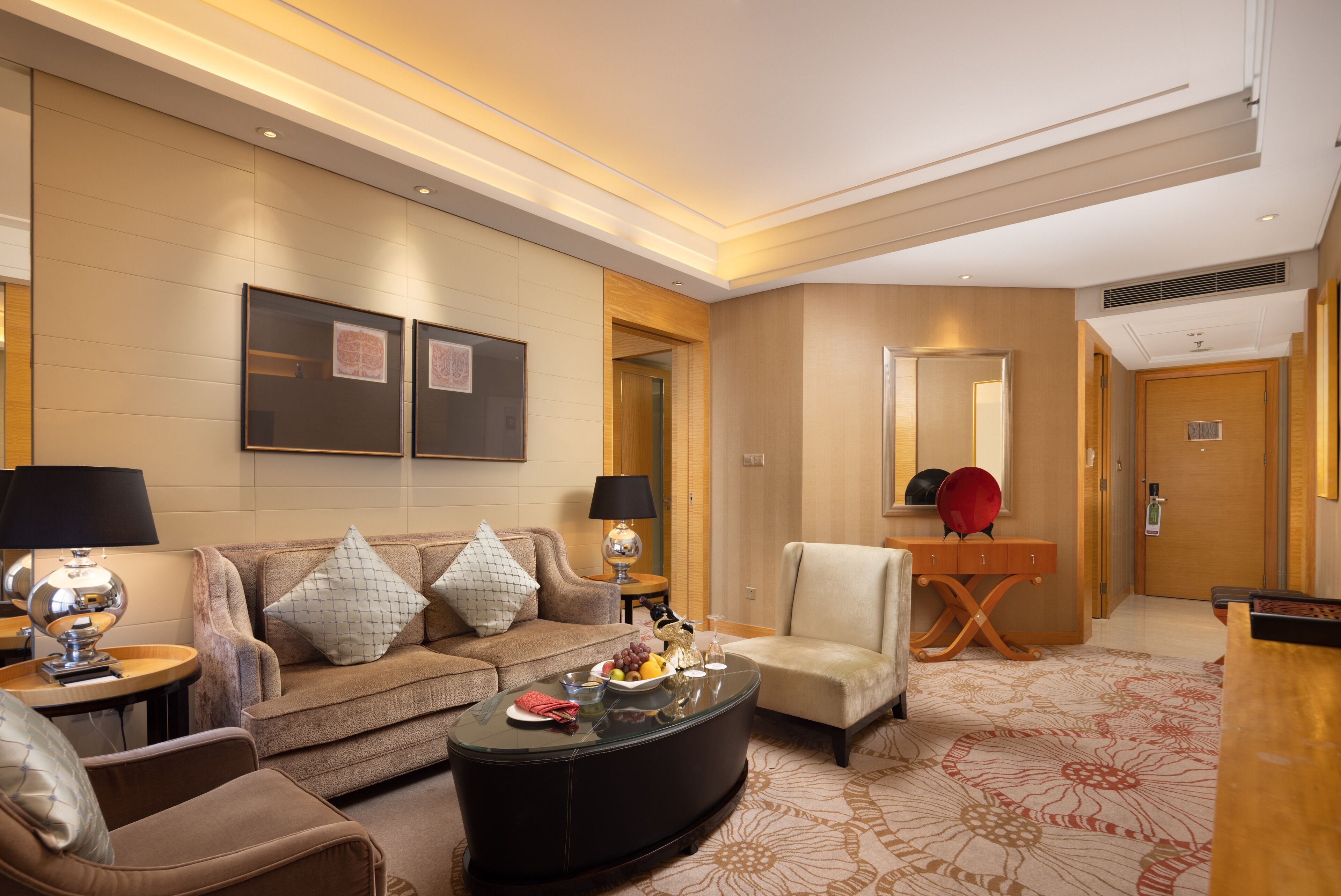 Un moderno vestíbulo de hotel con un sofá, sillones, una mesa de centro y una recepción.
