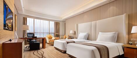 A hotel room with a large bed, a desk, a chair, and a TV.