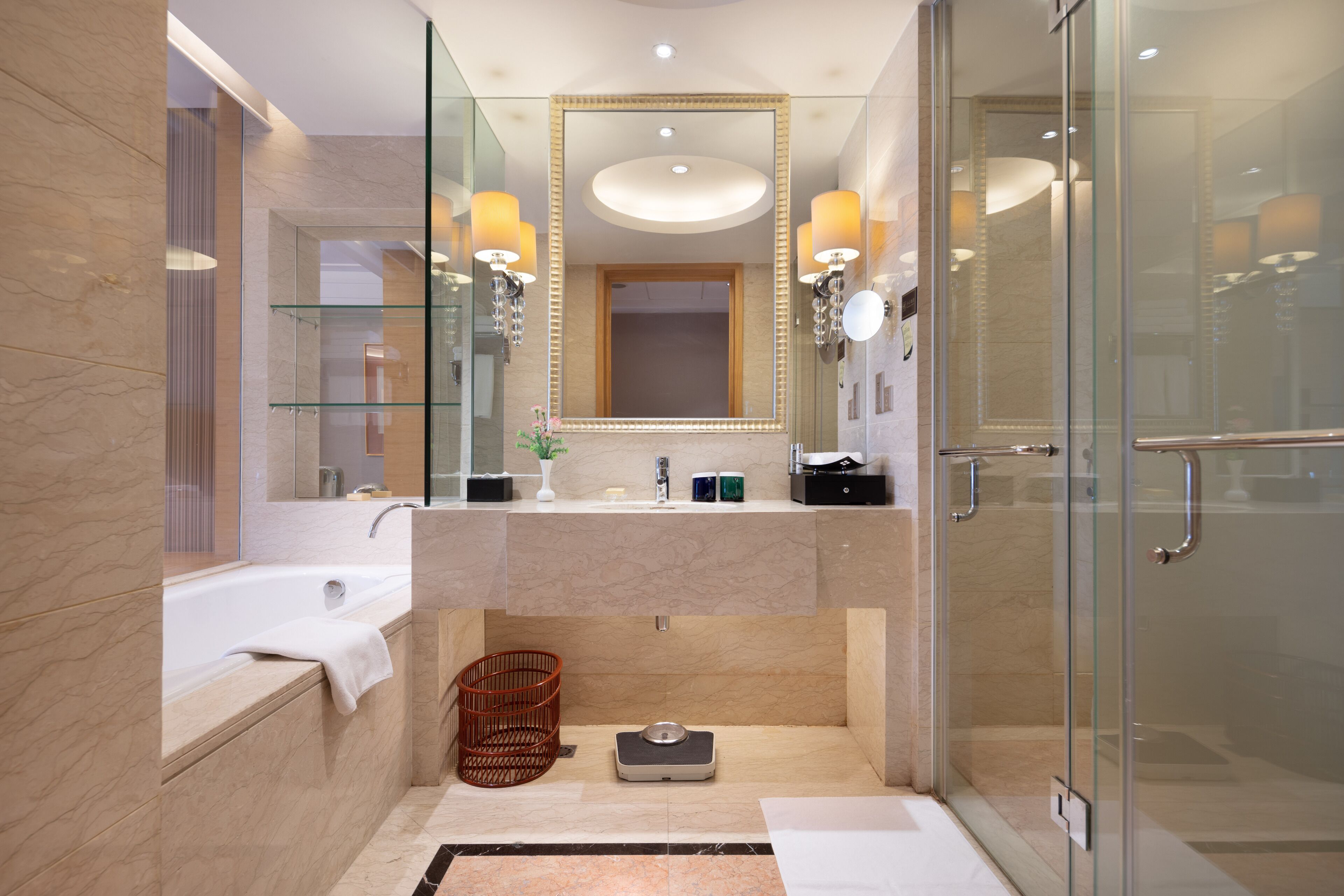 A modern bathroom with a glass shower enclosure, a large mirror, and a bathtub.