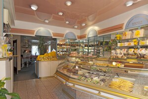 A bakery with a variety of baked goods displayed in glass cases.